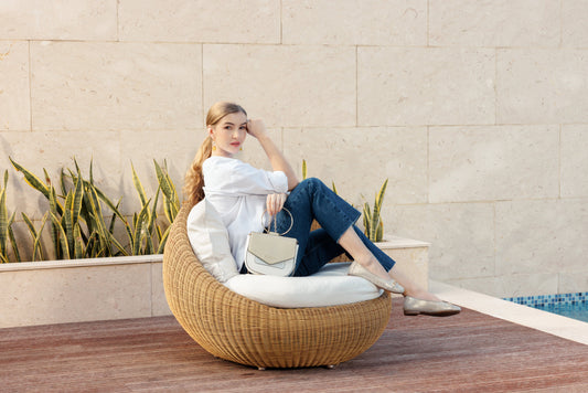 Woman in a white shirt and jeans relaxing poolside in bright summer light, wearing metallic remonte flats.