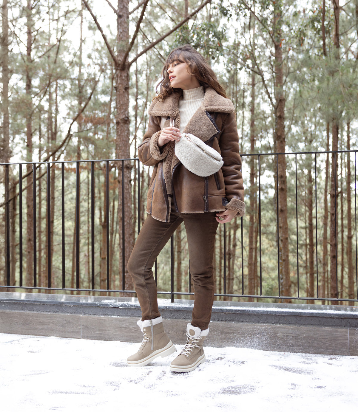 Woman wearing remonte shearling winter boots and jacket outdoors in the snow